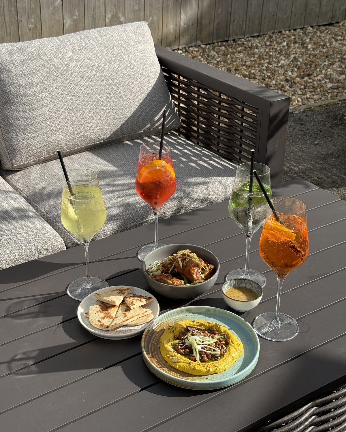 Sharing plates of hummus, flatbread and bao with spritzes and wine on the Courtyard terrace at The Glasshouse, Windlesham